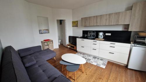 un salon avec un canapé et une cuisine dans l'établissement F3 original Maison bourgeoise Port Boinot, à Niort