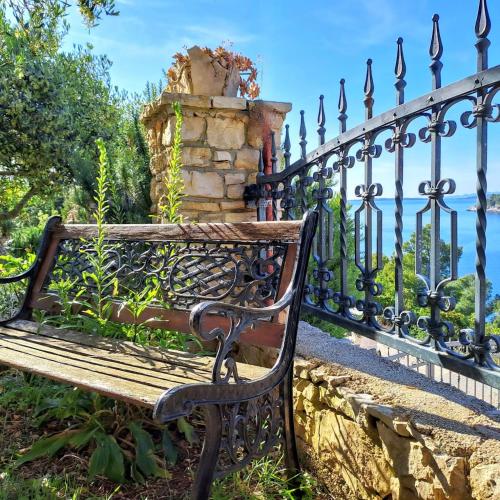a park bench in front of a fence at Villa Stone House Poplat in Vela Luka