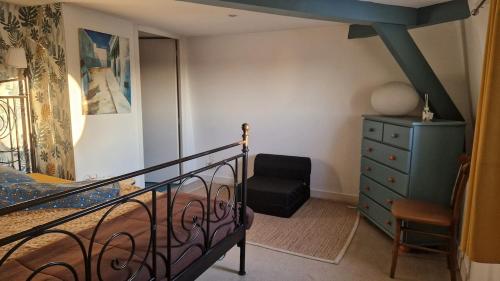 une chambre avec un lit, une commode et une chaise dans l'établissement F3 original Maison bourgeoise Port Boinot, à Niort