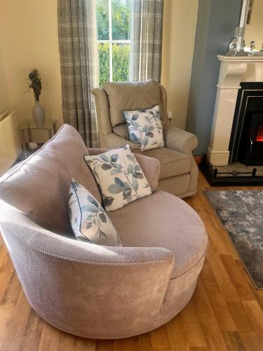 a living room with a couch and a chair and a fireplace at Lattone House in Belcoo
