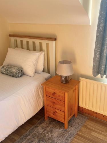 a bedroom with a bed and a table with a lamp at Lattone House in Belcoo