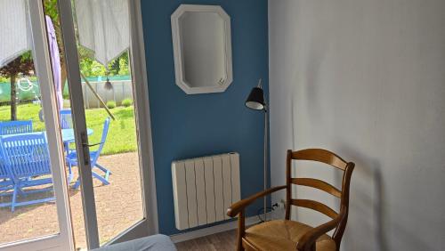 une pièce bleue avec une chaise et un radiateur dans l'établissement Le Bleuet de Montbazon, à Montbazon