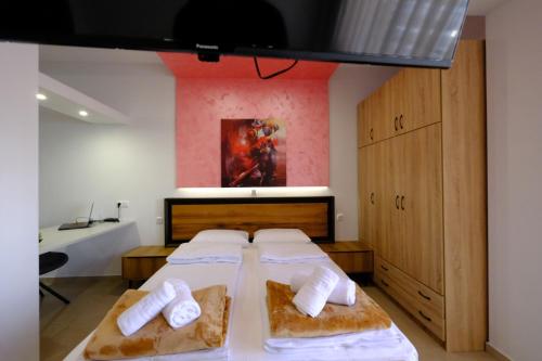 a bedroom with two beds and a painting on the wall at Eva House 2 in Drama