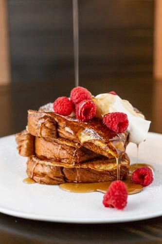 a stack of french toast with whipped cream and raspberries at Hotel LeVeque, Autograph Collection in Columbus