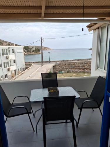 a table and chairs on a balcony with a view of the ocean at Με θέα τον όρμο της Βάρης in Vari