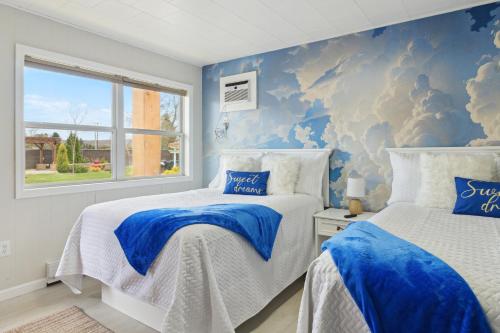 two beds in a bedroom with a blue wall at Pleasant Valley Resort in Arcadia