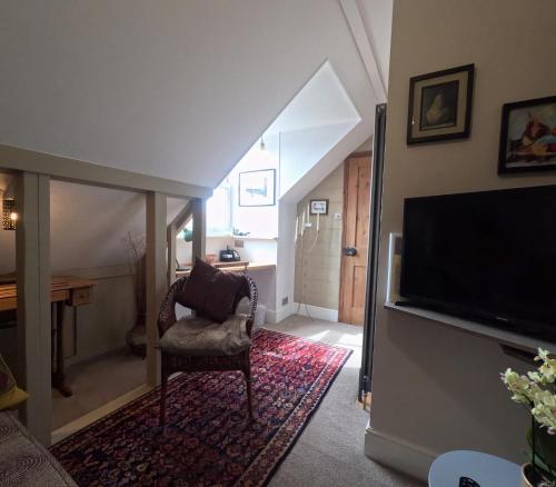 a living room with a flat screen tv and a chair at St Elmo Felixstowe in Felixstowe