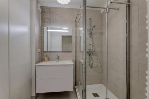 une salle de bain avec un lavabo blanc et une douche dans l'établissement Les rives de la Sèvre, à Vertou