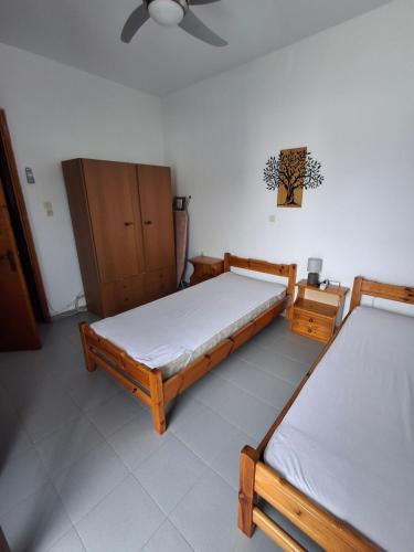 a bedroom with two beds and a cabinet at Με θέα τον όρμο της Βάρης in Vari