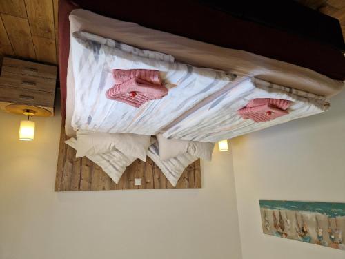 a bed with pink towels on a wall at Ferienhaus Petri Heil in Oberlangen