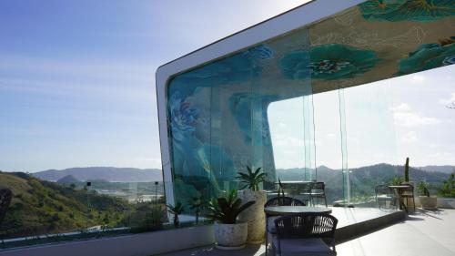 a room with a large window with mountains in the background at Truntum Boutique Mandalika in Kuta Lombok