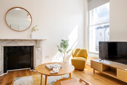 a living room with a fireplace and a mirror at The Fulham Residences in London