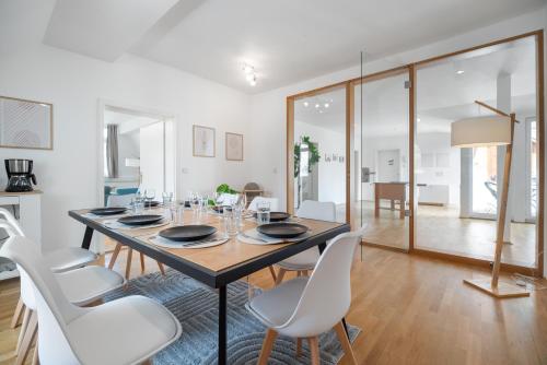 a dining room with a table and white chairs at Schloss-Apartment KOSELIG in Weimar