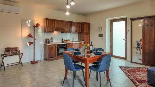 a kitchen with a wooden table and blue chairs at Asteria Guest&Artist House - Casa Tersìcore in Roseto Valfortore