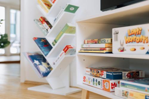 a white book shelf filled with lots of books at Schloss-Apartment KOSELIG in Weimar
