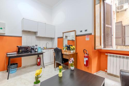 a kitchen with orange and white walls and a table at STELLA GUEST HOUSE O AFFITTACAMERE in Rome