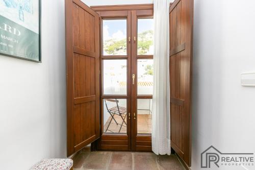 a wooden door with a window in a room at La Casa de la Iglesia in Mijas