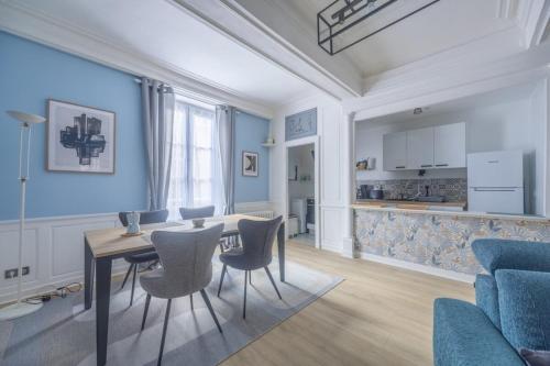 a living room with a table and chairs and a kitchen at La Belle Epoque in Bayeux