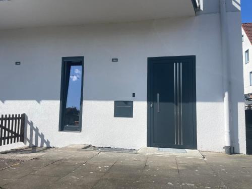 a black door on the side of a white building at PAULINEN Residenz in Detmold