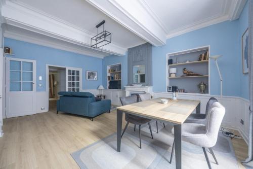 a dining room with blue walls and a table and chairs at La Belle Epoque in Bayeux
