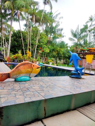two fish statues sitting next to a swimming pool at Pousada Lua e Mar in Belém