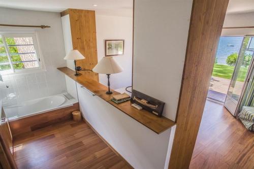 La salle de bains est pourvue d'une baignoire et d'une table avec une lampe. dans l'établissement Villa Hortensia, à La Teste-de-Buch