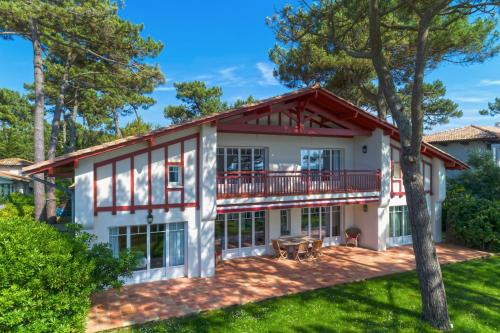 Elle offre une vue sur l'extérieur d'une maison dotée d'un balcon. dans l'établissement Villa Hortensia, à La Teste-de-Buch