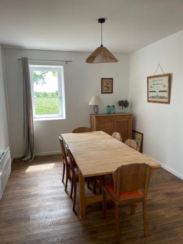 a dining room with a wooden table and chairs at Maison des Vendanges in Cesset