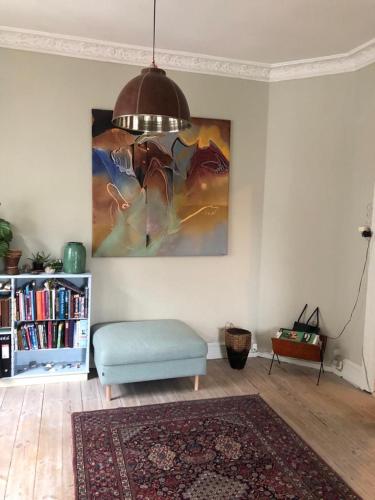 a living room with a couch and a painting on the wall at Best location at Vesterbro in Copenhagen