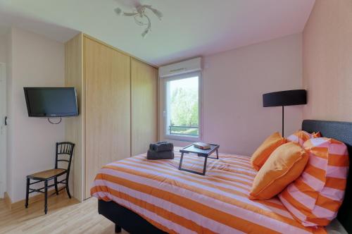 - une chambre avec un lit, une télévision et une chaise dans l'établissement Les rives de la Sèvre, à Vertou