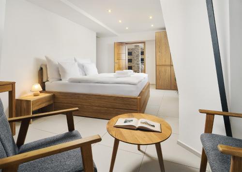 a bedroom with a bed and a chair and a table at IMPERIAL Apartments in Karlovy Vary