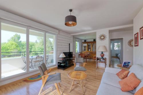 d'un salon avec un canapé et un balcon. dans l'établissement Les rives de la Sèvre, à Vertou