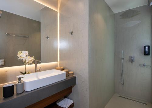 a bathroom with a sink and a shower at Porti Villas Aphrodite in Asómatoi