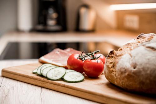 a cutting board with tomatoes and a loaf of bread at Paradies Im Schwarzwald in Bad Peterstal-Griesbach