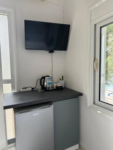 a flat screen tv on a wall above a dishwasher at Potami Seashell in Himare