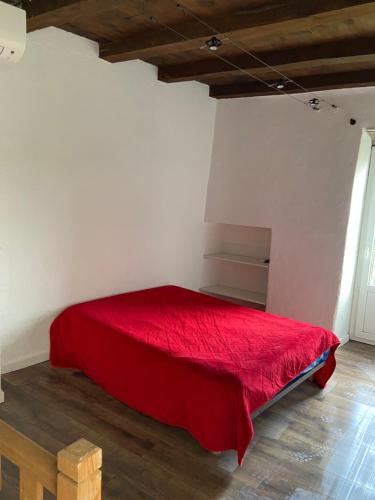 une chambre avec un lit rouge dans une pièce dans l'établissement Sottu à a Citadella, à Corte
