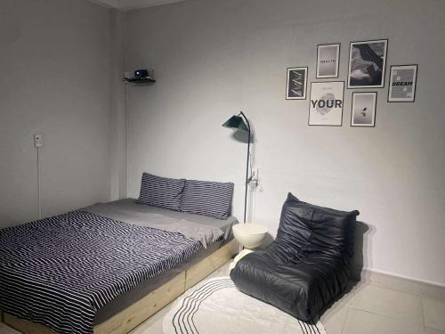 a bedroom with a bed and a chair at Full House Cát Bà in Cat Ba