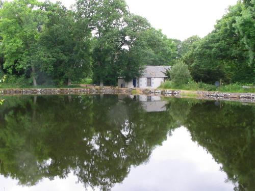 uma casa sentada ao lado de um corpo de água em Pond Cottage em Covington