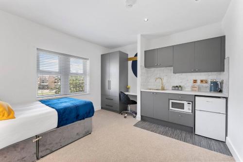 a small bedroom with a bed and a kitchen at Westland House En-suite Whole in Peterborough