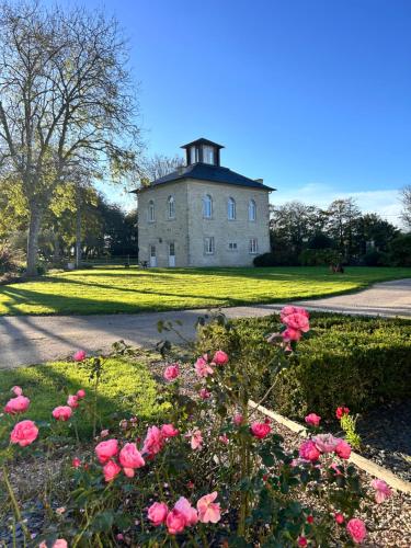 Saint-Germain-de-VarrevilleにあるGîte Vaugoubertの花畑の上に塔のある家