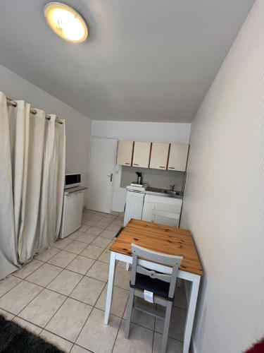 une cuisine avec une table en bois et un réfrigérateur dans l'établissement Studio lumineux Paris 20, à Paris
