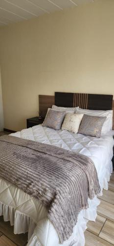 een slaapkamer met een groot bed met witte lakens en kussens bij Leonella Luxury Apartment in Northwold