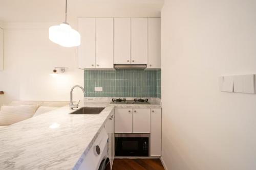 a kitchen with white cabinets and a sink at Tonight Homestay West Nanjing Road Shanghai in Shanghai