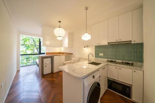 a kitchen with white cabinets and a dishwasher at Tonight Homestay West Nanjing Road Shanghai in Shanghai