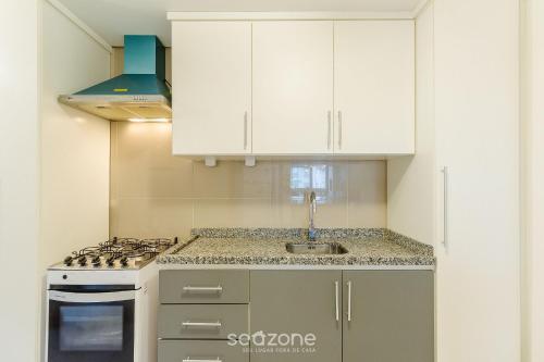 eine Küche mit weißen Schränken und einem Herd in der Unterkunft Apto em Canela de frente ao lago dos patos CBL307 in Canela