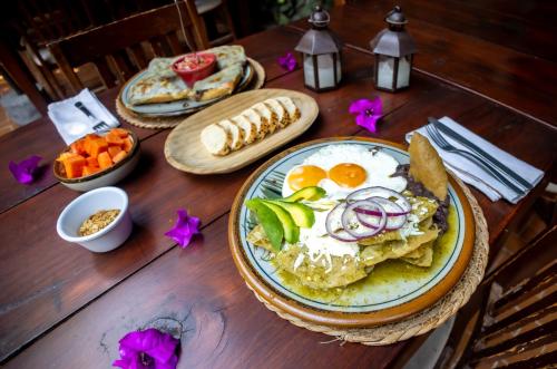 a wooden table topped with plates of breakfast foods at Hacienda Gobernadores in Mexico City