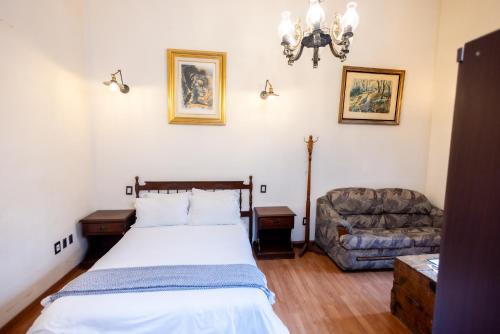 a bedroom with a bed and a couch at Hacienda Gobernadores in Mexico City