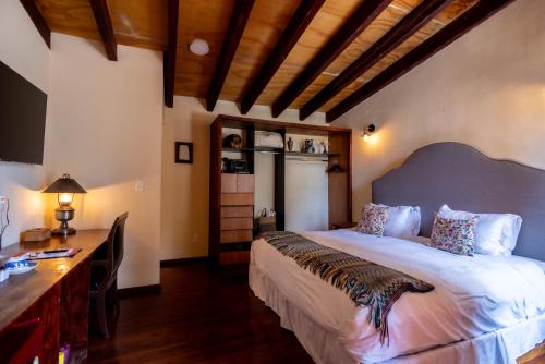 a bedroom with a large bed and a desk at Hacienda Gobernadores in Mexico City