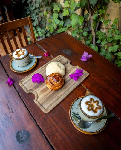 a wooden table with two cups of coffee and pastries at Hacienda Gobernadores in Mexico City