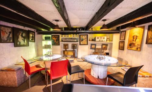a room with two tables and chairs and paintings on the walls at Hacienda Gobernadores in Mexico City